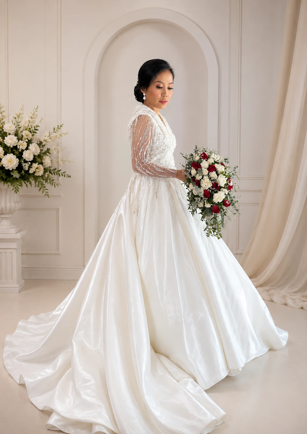 Bride wearing an elegant white wedding gown with pearl-beaded sheer sleeves and a flowing skirt from Myra’s Bridal Boutique.